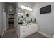 Bathroom vanity with granite counters, white cabinets, modern lighting, and a decorative mirror at 633 Hart Lake Dr, Winter Haven, FL 33884