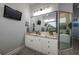 Well-lit bathroom with granite countertops, a large mirror, and a television at 633 Hart Lake Dr, Winter Haven, FL 33884