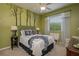 Cozy bedroom featuring a unique tree-themed wall design, neutral carpet and a ceiling fan for added comfort at 633 Hart Lake Dr, Winter Haven, FL 33884