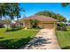 Charming single-story home with well-manicured lawn, mature trees, and inviting front entrance at 633 Hart Lake Dr, Winter Haven, FL 33884