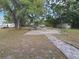 Expansive backyard with large trees, brick patio, and ample space for recreation at 700 E Park Rd, Haines City, FL 33844