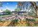 Lush backyard featuring a patio with a swing set beneath beautiful shade trees at 700 E Park Rd, Haines City, FL 33844