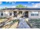 Back of house with an enclosed patio, lawn, and brick walkway to the home's entrance at 700 E Park Rd, Haines City, FL 33844