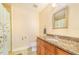 Well-lit bathroom with a granite countertop, wooden vanity, and shower with floral curtain at 700 E Park Rd, Haines City, FL 33844