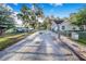 Gated driveway and front yard with large shade trees at 700 E Park Rd, Haines City, FL 33844