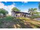 A view of the back of house with backyard, lawn and some beautiful trees at 700 E Park Rd, Haines City, FL 33844