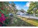 Lovely single-story home with attached garage, chain link fence and gated entrance, shaded by mature trees at 700 E Park Rd, Haines City, FL 33844