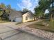 View of the home, highlighting the attached garage, brick-laid walkway, and partially screened-in porch at 700 E Park Rd, Haines City, FL 33844