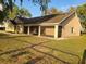 Tan single Gathering home featuring an attached garage and a covered and screened-in porch, perfect for outdoor enjoyment at 700 E Park Rd, Haines City, FL 33844
