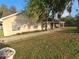 View of the front of a well maintained tan single-Gathering home with a screened-in porch and brick walkway at 700 E Park Rd, Haines City, FL 33844