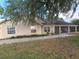 Single-story home with a covered porch, beautiful landscaping, and lush greenery, offering a welcoming curb appeal at 700 E Park Rd, Haines City, FL 33844