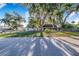 Charming single-story home featuring mature trees and a well-maintained lawn behind a decorative metal chainlink fence at 700 E Park Rd, Haines City, FL 33844