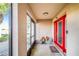 Welcoming front porch with a bright red door and adjacent screened in area at 700 E Park Rd, Haines City, FL 33844