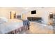 Light-filled main bedroom with wood-look tile floors, dual dressers, and mounted television at 700 E Park Rd, Haines City, FL 33844