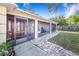 View of the screened-in porch, showcasing the inviting red door, ample space, and outdoor seating at 700 E Park Rd, Haines City, FL 33844