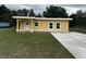 Charming single-story home with a sunny yellow exterior and a spacious concrete driveway at 708 E Broadway St, Fort Meade, FL 33841