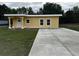 Charming single-story home with a sunny yellow exterior and a spacious concrete driveway at 708 E Broadway St, Fort Meade, FL 33841