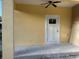 Covered patio with ceiling fan and white door at 708 E Broadway St, Fort Meade, FL 33841
