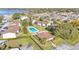Aerial view of a community pool and building surrounded by houses, greenery, and a lake at 900 Avenue Z Se # A3, Winter Haven, FL 33880