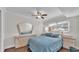 Comfortable bedroom featuring blue bedding, ceiling fan, and light-colored dresser with large mirror at 900 Avenue Z Se # A3, Winter Haven, FL 33880