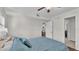 Bedroom with patterned blue bedding, ceiling fan, and view into the room beyond open white door at 900 Avenue Z Se # A3, Winter Haven, FL 33880