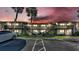 Two-story building with a parking lot in front and palm trees, under a red sky at dusk at 900 Avenue Z Se # A3, Winter Haven, FL 33880