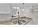 Modern kitchen with stainless steel double sink and decorative pendant lighting at 900 Avenue Z Se # A3, Winter Haven, FL 33880