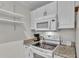 Well-equipped kitchen with white appliances, granite counters, and open shelving at 900 Avenue Z Se # A3, Winter Haven, FL 33880