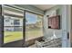 Enclosed patio with view of the building exterior beyond window blinds and white metal chairs at 900 Avenue Z Se # A3, Winter Haven, FL 33880