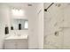 Well-lit bathroom features a modern sink and vanity, alongside a marble-tiled shower with a glass door at 919 Avenue S Se, Winter Haven, FL 33880