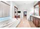 Bright bathroom boasts double vanity, bathtub with jacuzzi, and tiled floor at 926 S Lakeshore Blvd, Lake Wales, FL 33853