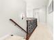 Second floor hallway with neutral paint and carpet, wood, and rod iron railing at 926 S Lakeshore Blvd, Lake Wales, FL 33853