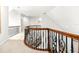 Second floor hallway with wood and rod iron railing and neutral carpet at 926 S Lakeshore Blvd, Lake Wales, FL 33853