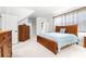 Bright main bedroom boasts a wooden bed frame, dresser, and carpeted floors at 926 S Lakeshore Blvd, Lake Wales, FL 33853