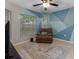 Stylish bedroom with geometric wall design, comfortable recliner and tile flooring at 991 Old Scenic Hwy, Lake Wales, FL 33853