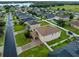 Aerial view of a residential neighborhood with well-maintained lawns and community lake in the distance at 10234 Lenox St, Clermont, FL 34711