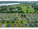 Panoramic aerial view of a residential neighborhood with a lake, lush greenery, and manicured lawns at 10234 Lenox St, Clermont, FL 34711