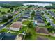 Aerial view of a charming two-story home with a well-manicured lawn and lake in the distance at 10234 Lenox St, Clermont, FL 34711
