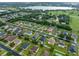 Panoramic aerial view of a residential neighborhood with a lake, lush greenery, and manicured lawns at 10234 Lenox St, Clermont, FL 34711