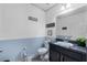 Well-lit bathroom featuring blue accent wall and dark vanity sink at 10234 Lenox St, Clermont, FL 34711