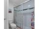 Bathroom showcasing a glass-enclosed shower with decorative tiles and a white toilet at 10234 Lenox St, Clermont, FL 34711