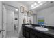 Bathroom features dual sinks, a large mirror, and tile flooring at 10234 Lenox St, Clermont, FL 34711