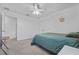 Bright bedroom featuring carpet, a queen bed, a ceiling fan, and a double door closet at 10234 Lenox St, Clermont, FL 34711