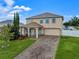 Charming two-story home with a manicured lawn, inviting porch, and brick driveway at 10234 Lenox St, Clermont, FL 34711