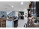 Open concept kitchen featuring stainless steel appliances, granite countertops and white tile flooring at 10234 Lenox St, Clermont, FL 34711