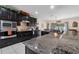 Well-lit kitchen featuring granite countertops, stainless steel appliances, and dark wood cabinetry at 10234 Lenox St, Clermont, FL 34711