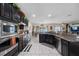 Open concept kitchen with white tile flooring, stainless steel appliances and dark wood cabinets at 10234 Lenox St, Clermont, FL 34711