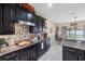 Kitchen with stainless steel appliances, granite countertops, decorative backsplash and dark wood cabinets at 10234 Lenox St, Clermont, FL 34711