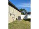 Side view of the home with a fenced-in backyard, air conditioning unit, and solar panels in the background at 1056 Naes Ln, Lake Wales, FL 33853