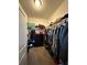 Walk-in closet with carpet and black three-drawer dresser filled with clothes and accessories at 1056 Naes Ln, Lake Wales, FL 33853
